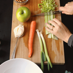 A person chopping celery on a cutting board