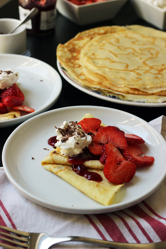 platter of crepes with plate of topped crepe