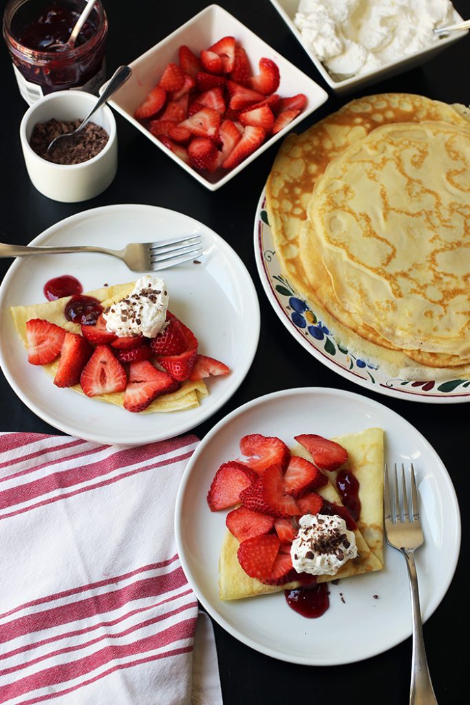 two plates of dessert crepes with toppings