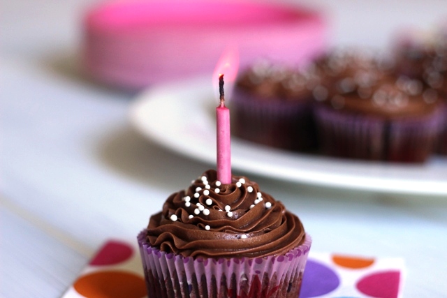 chocolate cupcake with chocolate buttercream and a candle in it