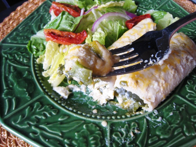 A plate of food with a fork, with Enchilada