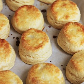 Flaky Buttermilk Biscuits cooling on parchment-lined tray