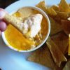 dipping a chip into cheese dip