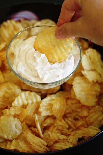 A close up of a chip in onion dip