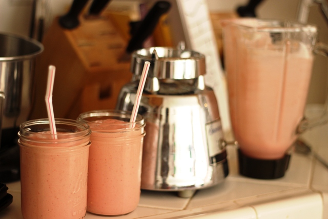 jars of smoothie next to blender on counter