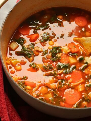 pot of stone soup on a red cloth on a black table.