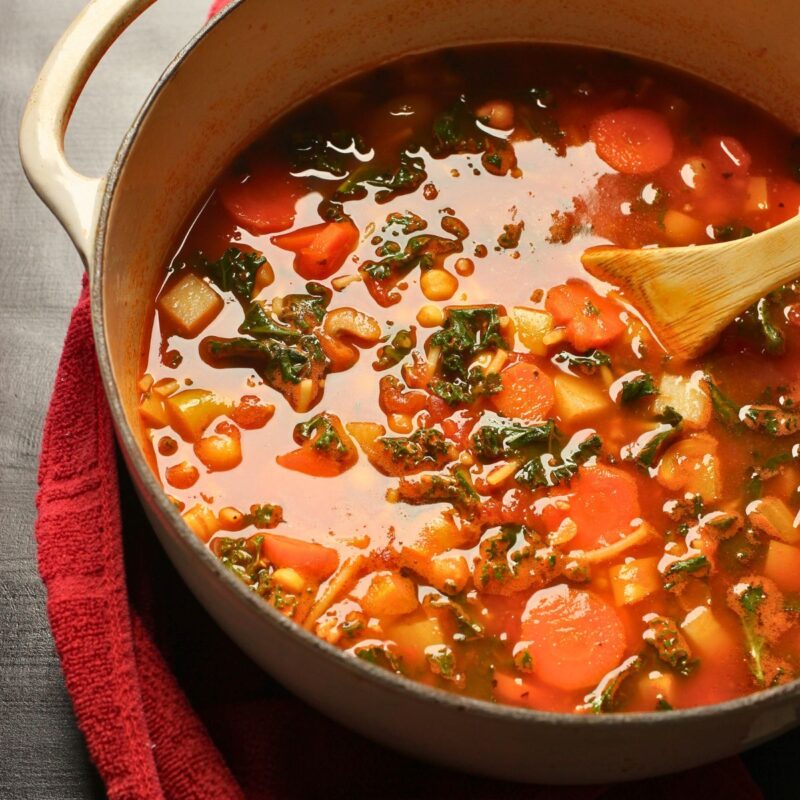 pot of stone soup on a red cloth on a black table.