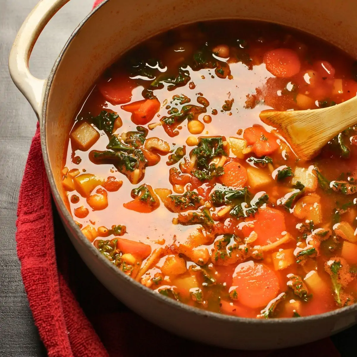 pot of stone soup on a red cloth on a black table.