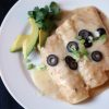 A plate of Enchiladas topped with olives