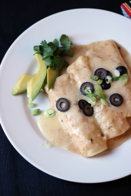 A plate of Enchiladas topped with olives