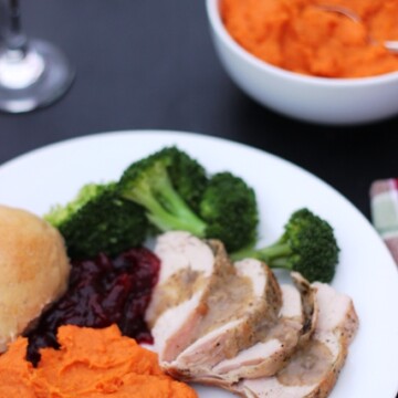 A plate of Thanksgiving food on a table, with bowls