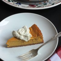 A slice of Pumpkin Cheesecake on a plate, with fork