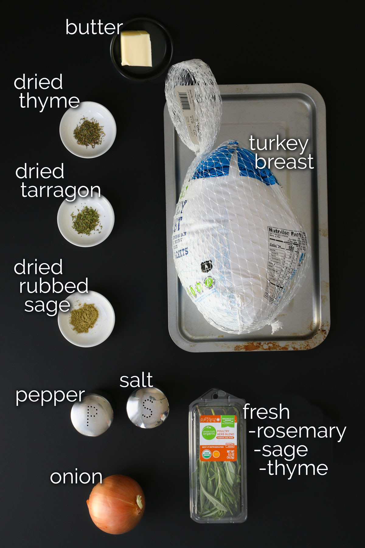 ingredients for roast turkey breast laid out on black table.