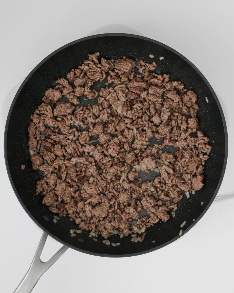 cooked ground beef and onion in a skillet.