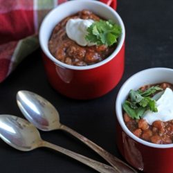 mugs of chili on table with spoons