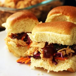 plate of sandwiches next to dish of pulled chicken