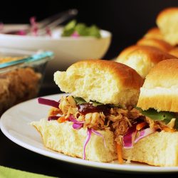 sweet and sour pulled chicken on hawaiian rolls on plate