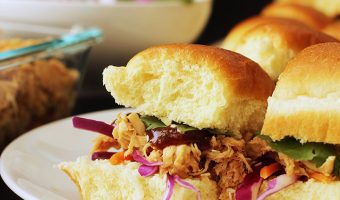 sweet and sour pulled chicken on hawaiian rolls on plate