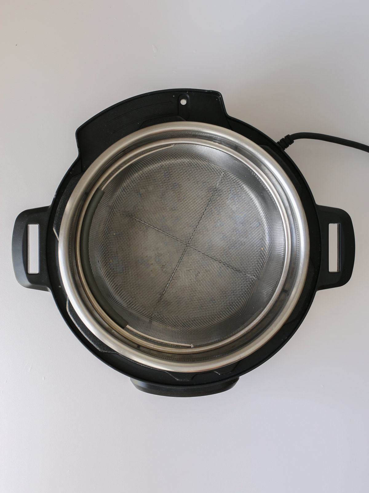 pressure cooker with steamer basket inserted.