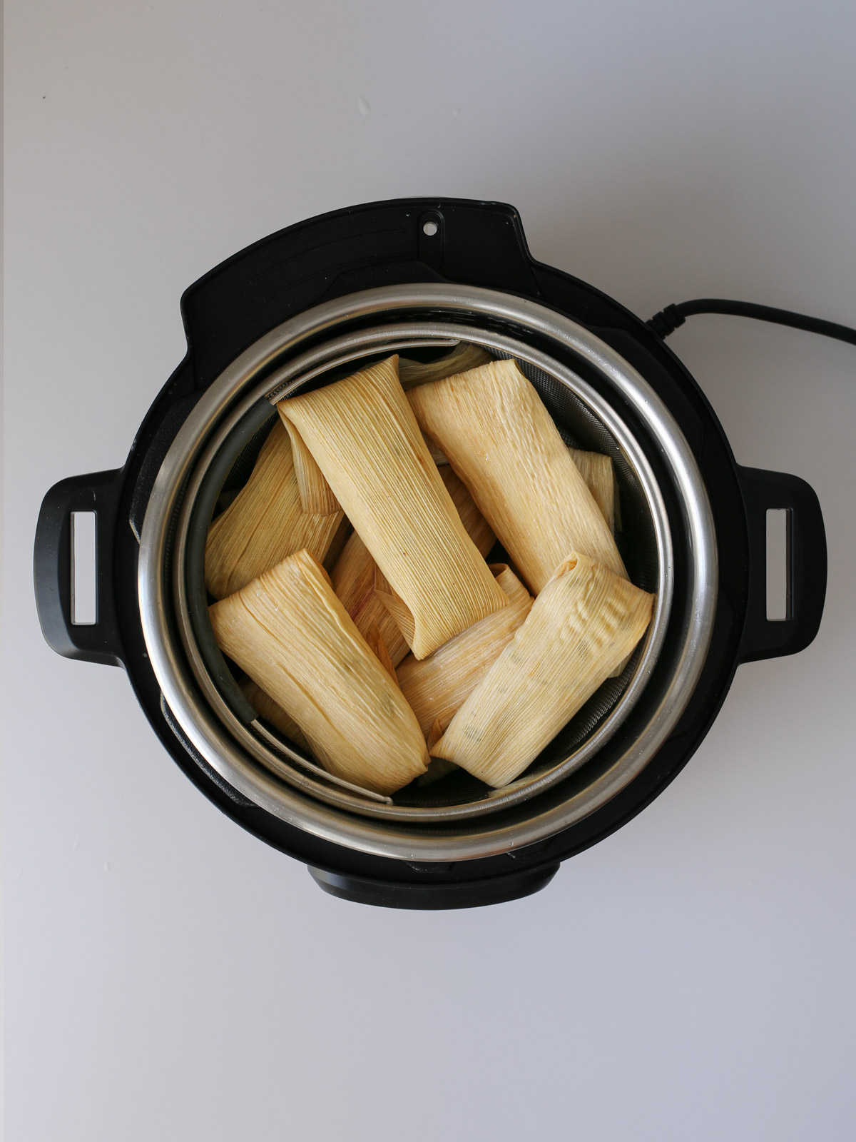 tamales piled into the steamer basket.