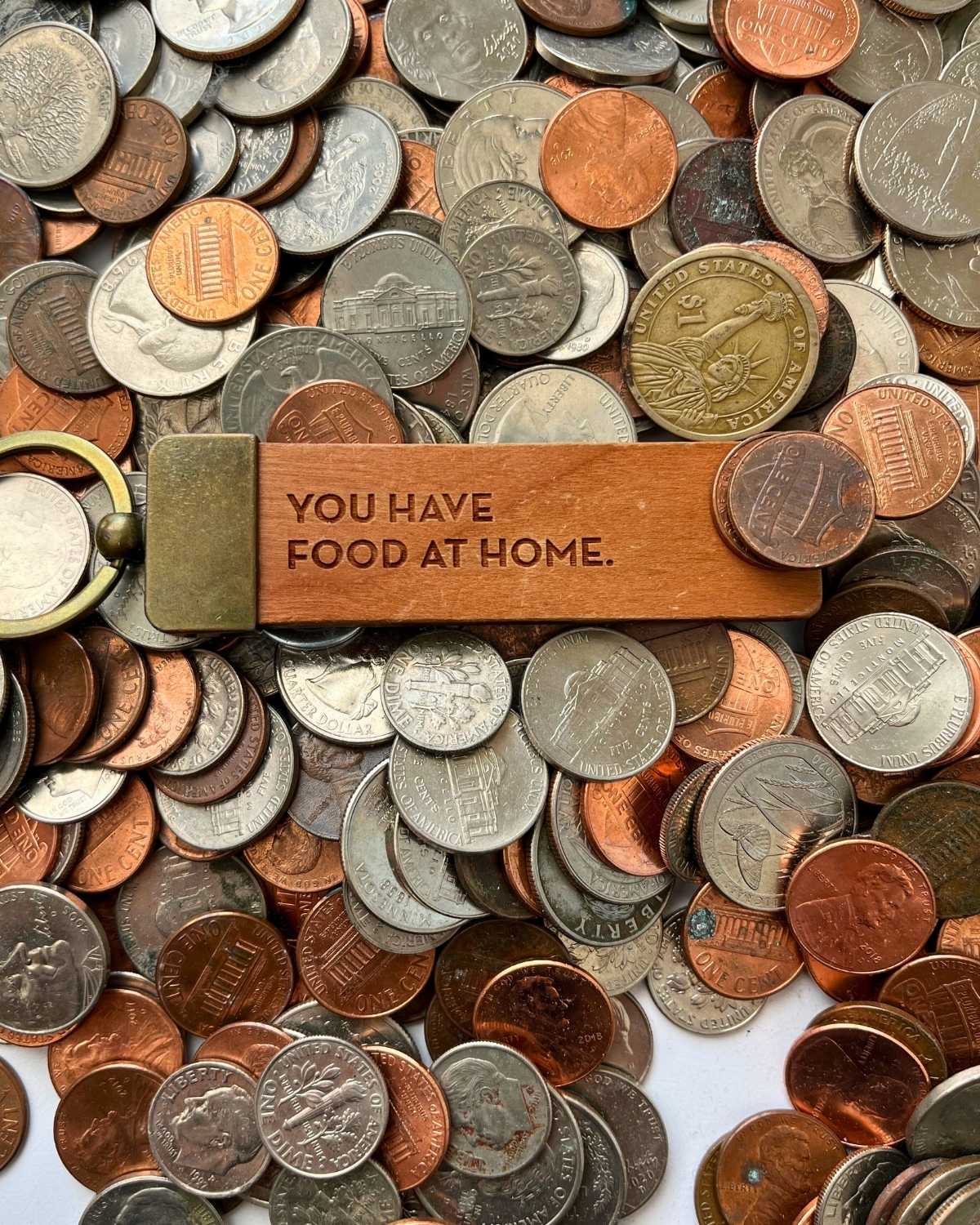 you have food at home keychain among piles of coins.