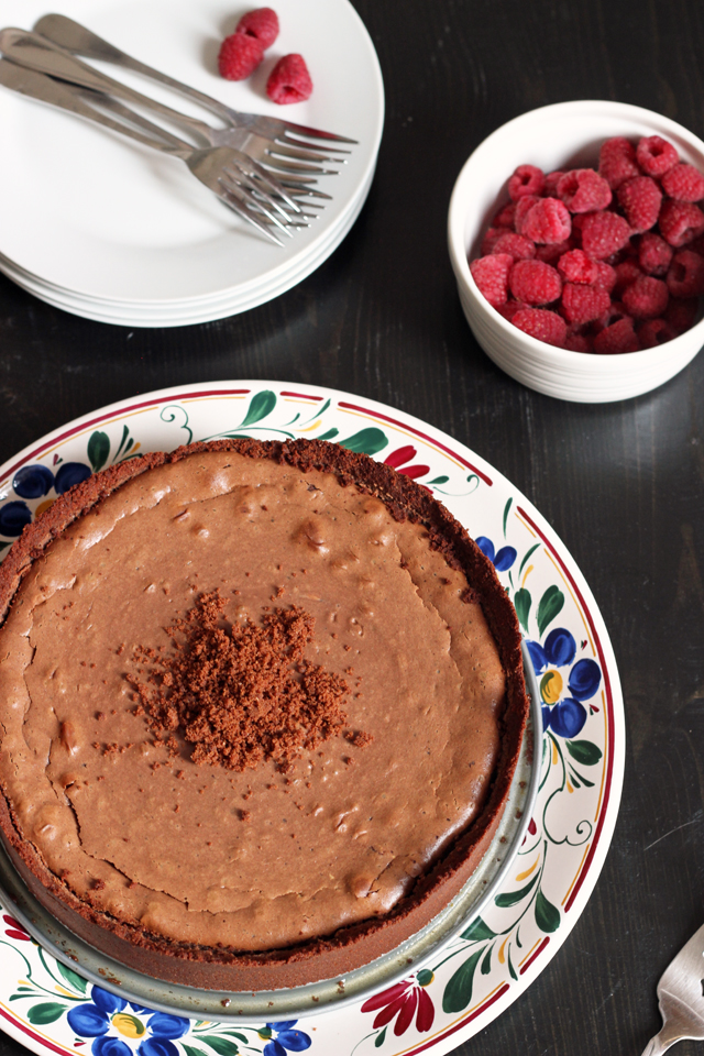 chocolate cheesecake with a bowl of raspberries