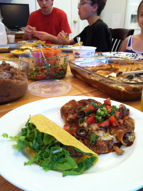 A group of people sitting at a table with a plates of tacos