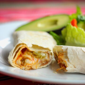 cut view of bean burrito with cheese and green chiles.