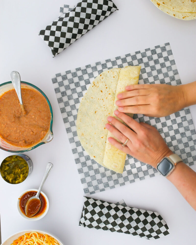 rolling up the burrito in deli paper.