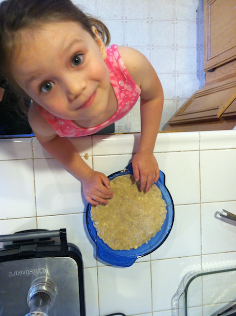 A little girl standing in a kitchen