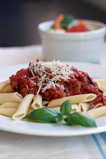 a plate of pasta and meat sauce on top