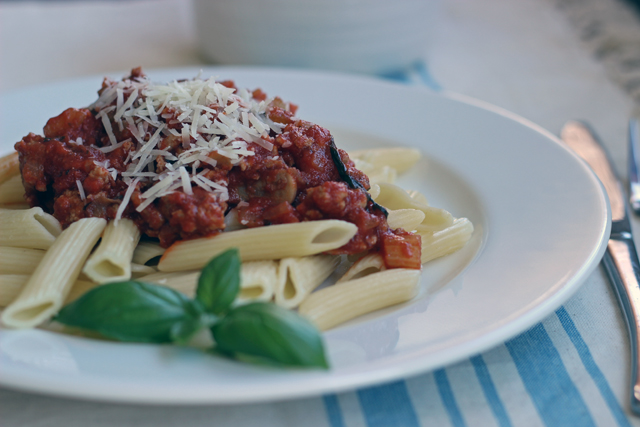 a plate of pasta with meat sauce on top