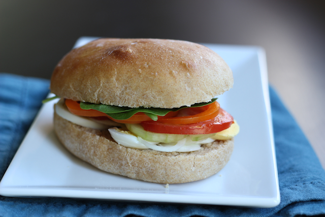 An egg sandwich cut in half on plate