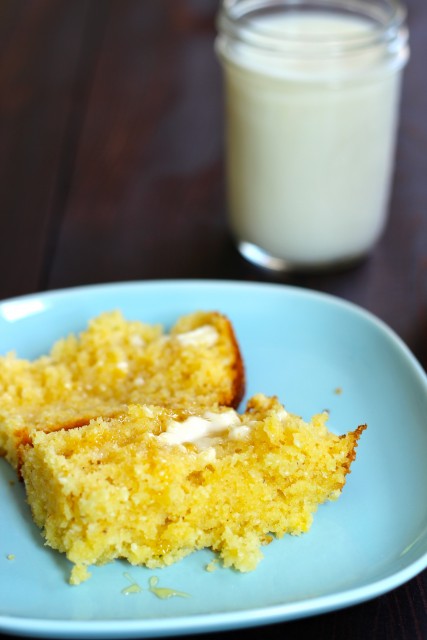 slice of honey cornbread on a plate with a glass of milk