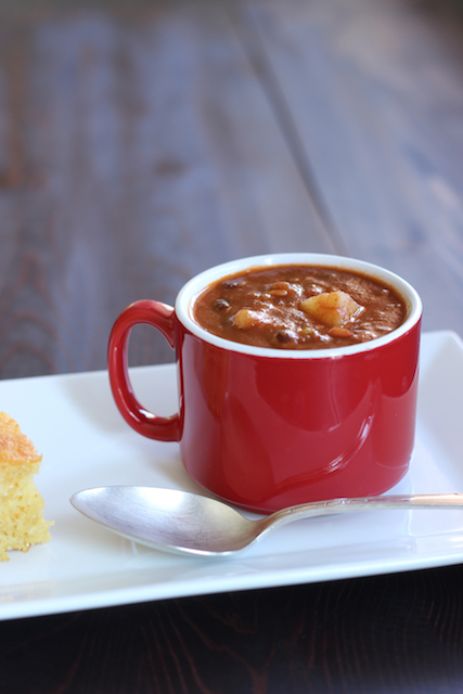 A mug of chili bean soup, with cornbread