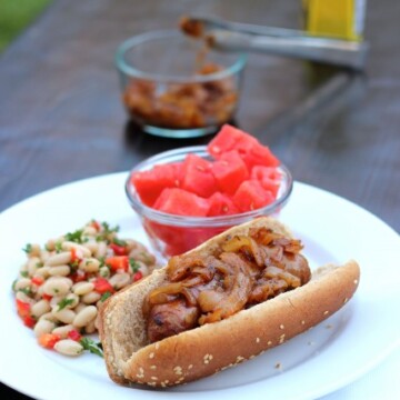 hot dog with onions on a plate with sides