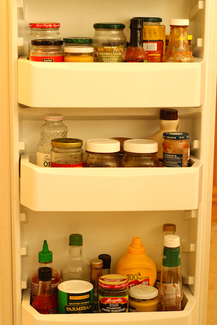An open refrigerator filled condiments