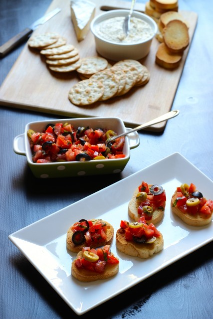 table set with platters of crackers and bruschetta