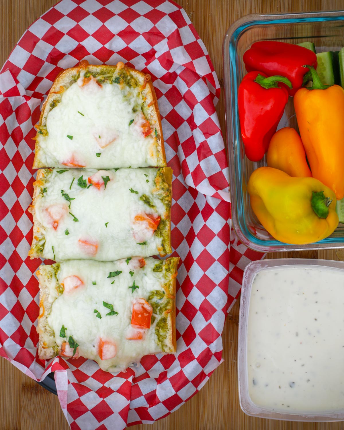 cooked french bread pizza in a basket next to ranch and veggie dippers.