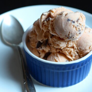 A close up of apricot ice cream in a blue ramekin