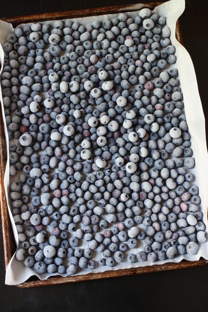 frozen blueberries on a rimmed, parchment-lined tray