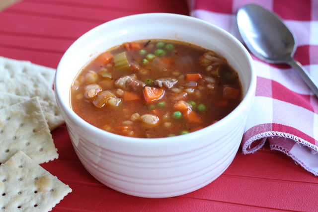 A bowl of beef soup on a red mat