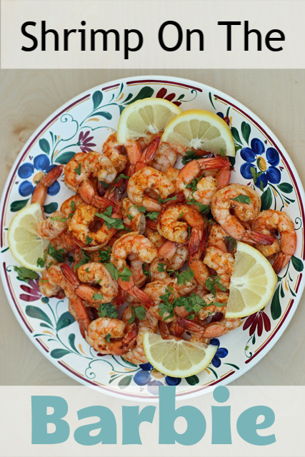 A plate of grilled shrimp and lemon wedges