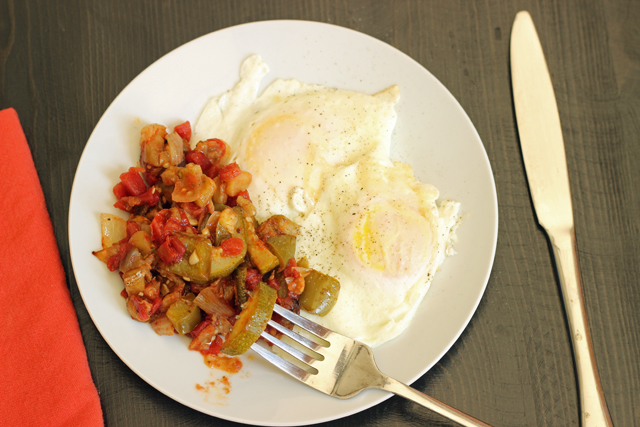 fried eggs on a plate of ratatouille