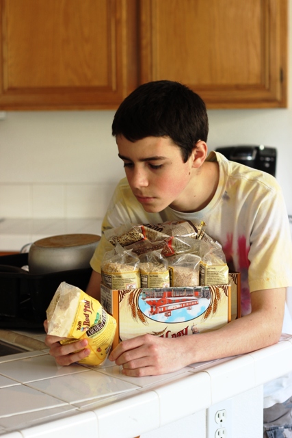 teen boy reading package of grains