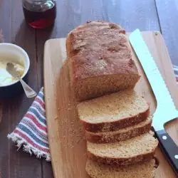 A loaf of bread sliced on wooden cutting board