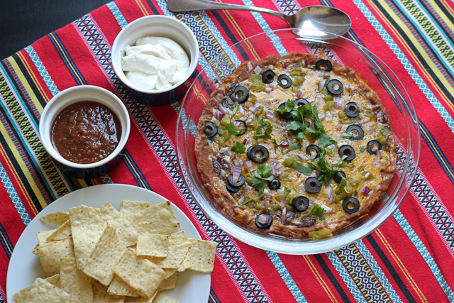 a plate of six layer nachos with plate of chips