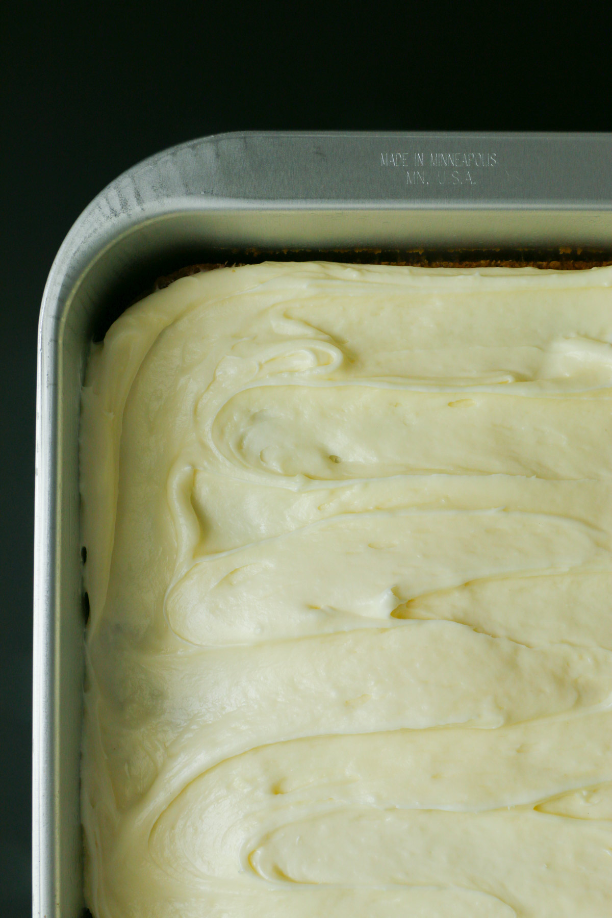 overhead shot of frosted zucchini cake in metal cake pan.