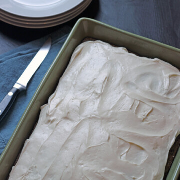 a baking dish with frosted zucchini cake