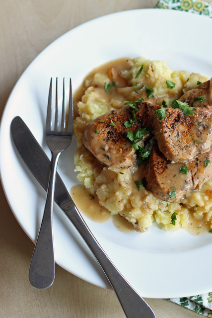 A plate of Pork tenderloin, with fork and knife